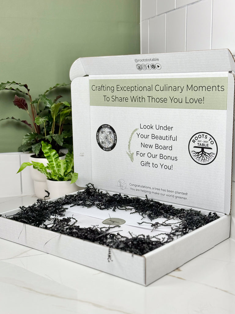 Image depicting the gift box perfectly packaged for gifting wooden walnut and maple cutting and charcuterie boards. The box is white with a scan code and information printed on the inside of the box. The board is wrapped in white paper and black crinkle paper fills the empty space for a finished look.