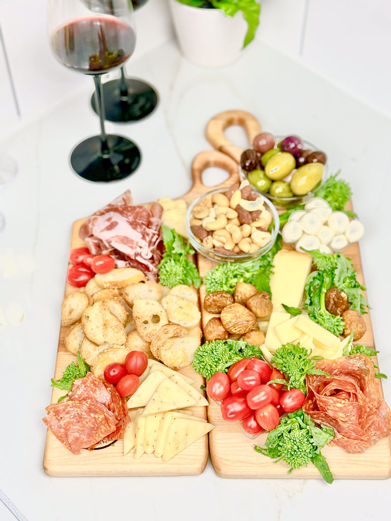 Two handcrafted wooden boards made from edge grain maple. Both feature ergonomic handles with a soft, rounded design, displayed on a textured fabric backdrop for a rustic aesthetic.