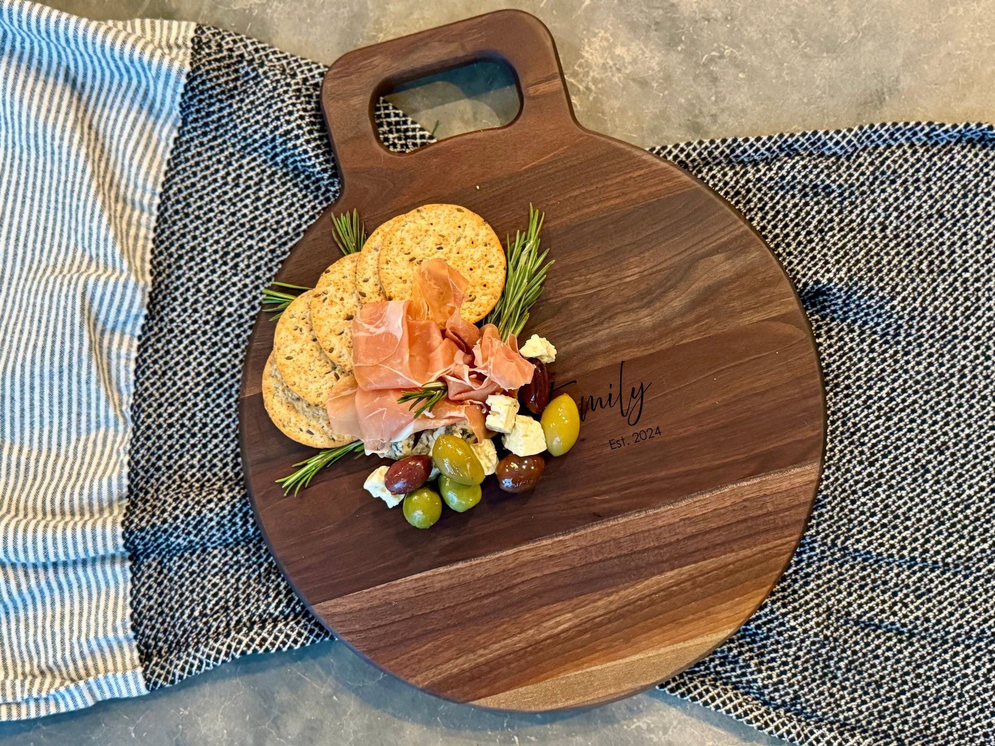 Walnut Charcuterie with Handle. Round board with food on it.