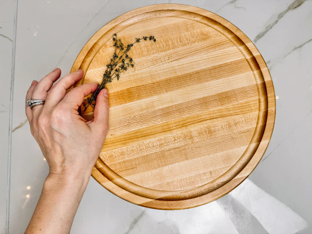 Round Maple Cutting Board with a piece of thyme 