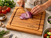 An edge grain maple cutting board with a rounded square shape and a built-in juice groove, featuring the engraved brand name THE GREENWOODS EST. 2025 in the bottom right corner. The small chopping board is ideal for compact spaces.