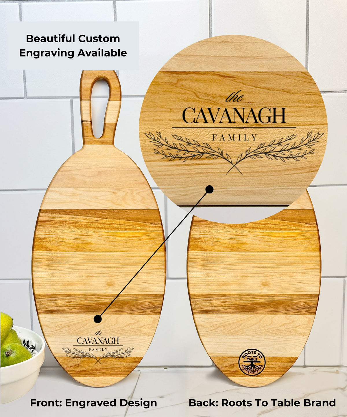 Oval wooden cutting board with a smooth finish, featuring a custom engraved design for The Cavanagh Family on the front and the Roots to Table brand logo on the back. Displayed against a white tiled background with pears in a bowl nearby.
