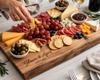 A large personalized wooden charcuterie board engraved with 'Shawn & April 10.12.