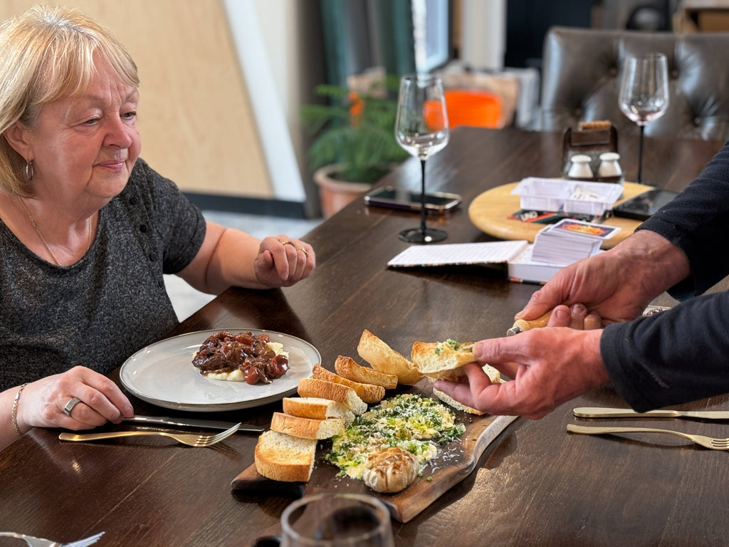 A family enjoys a butter board with fresh bread served on a live edge alnu charcuterie board.