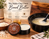 A tin of Board Butter balm and its lid are shown on a wooden countertop, with a slow cooker containing a creamy white mixture and beads, a small glass of golden liquid, and a branded sign in the background reading 'We Make Our Own Board Butter.'.