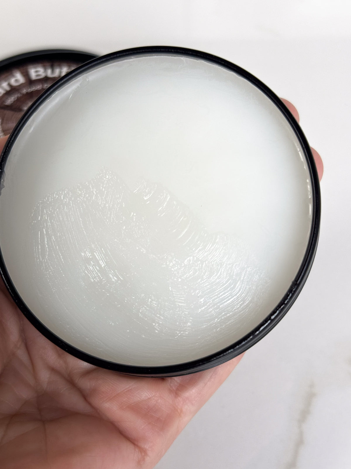 An open Tin of Roots to Table Board Butter, labeled as 100% food grade with ingredients including mineral oil, beeswax, and vitamin E. 