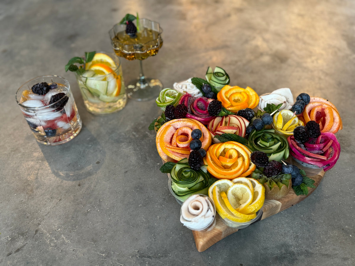 Custom engraved maple wood cutting board decorated with fruit flowers and featuring 3 cocktails.