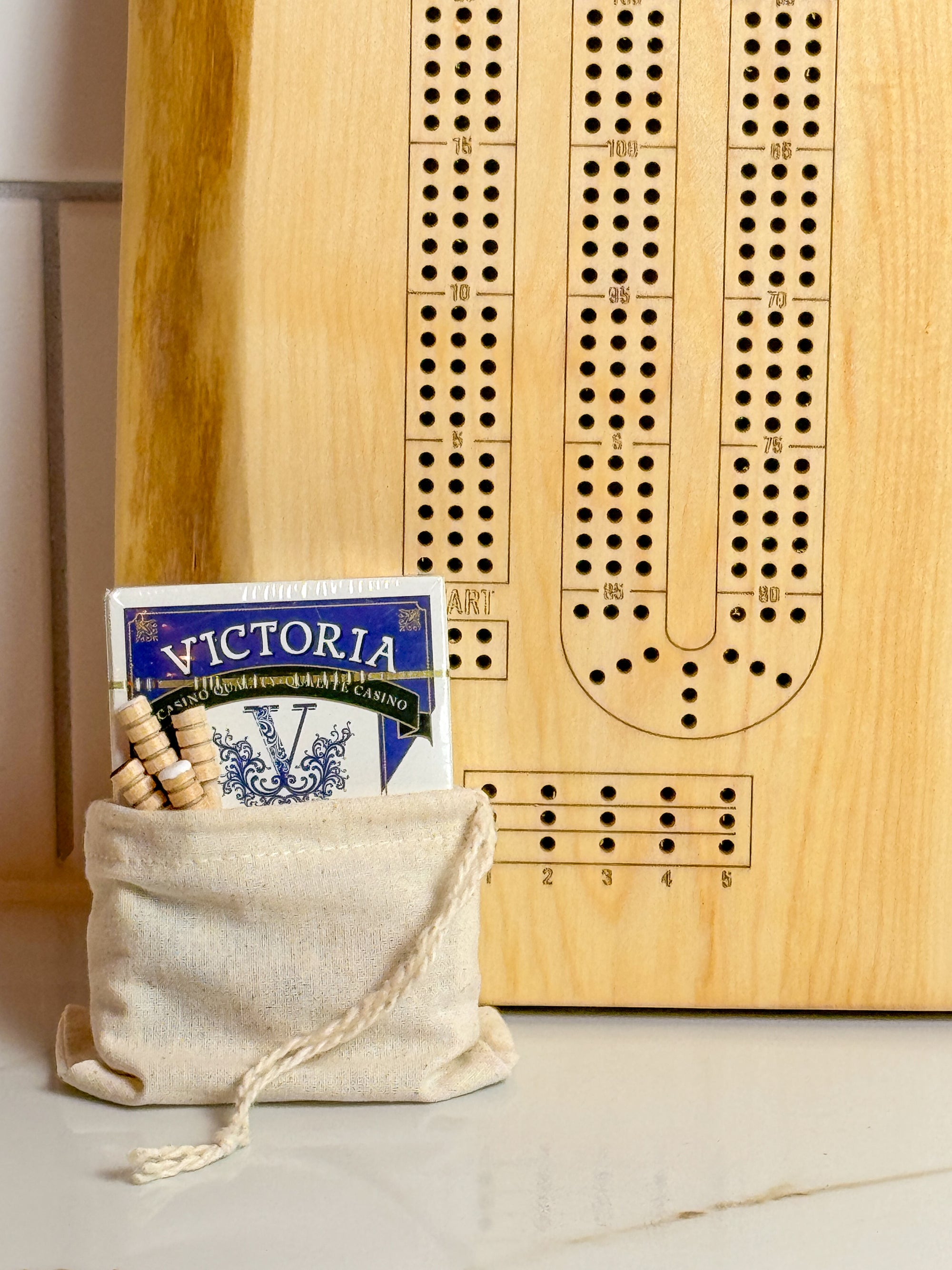 Image shows a finished live edge maple crib board with the full set. Set includes a small cloth sachet with a deck of cards and 9 wooden pegs.