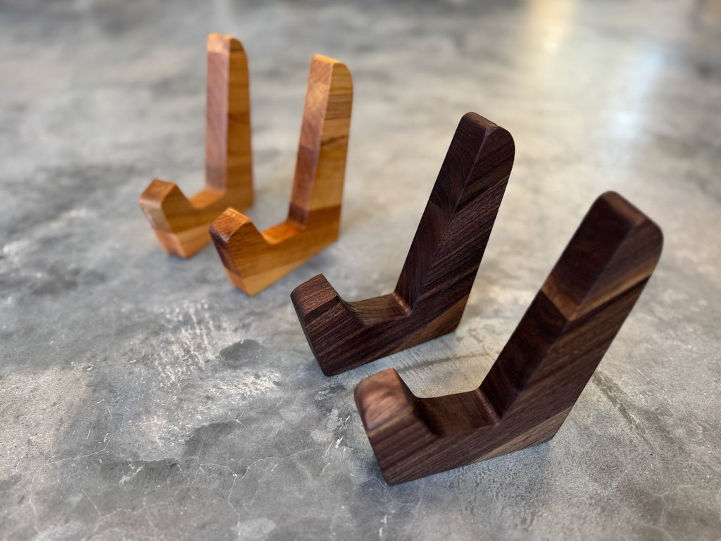 Two standing sets of cutting board stands. One set is maple and one set is walnut