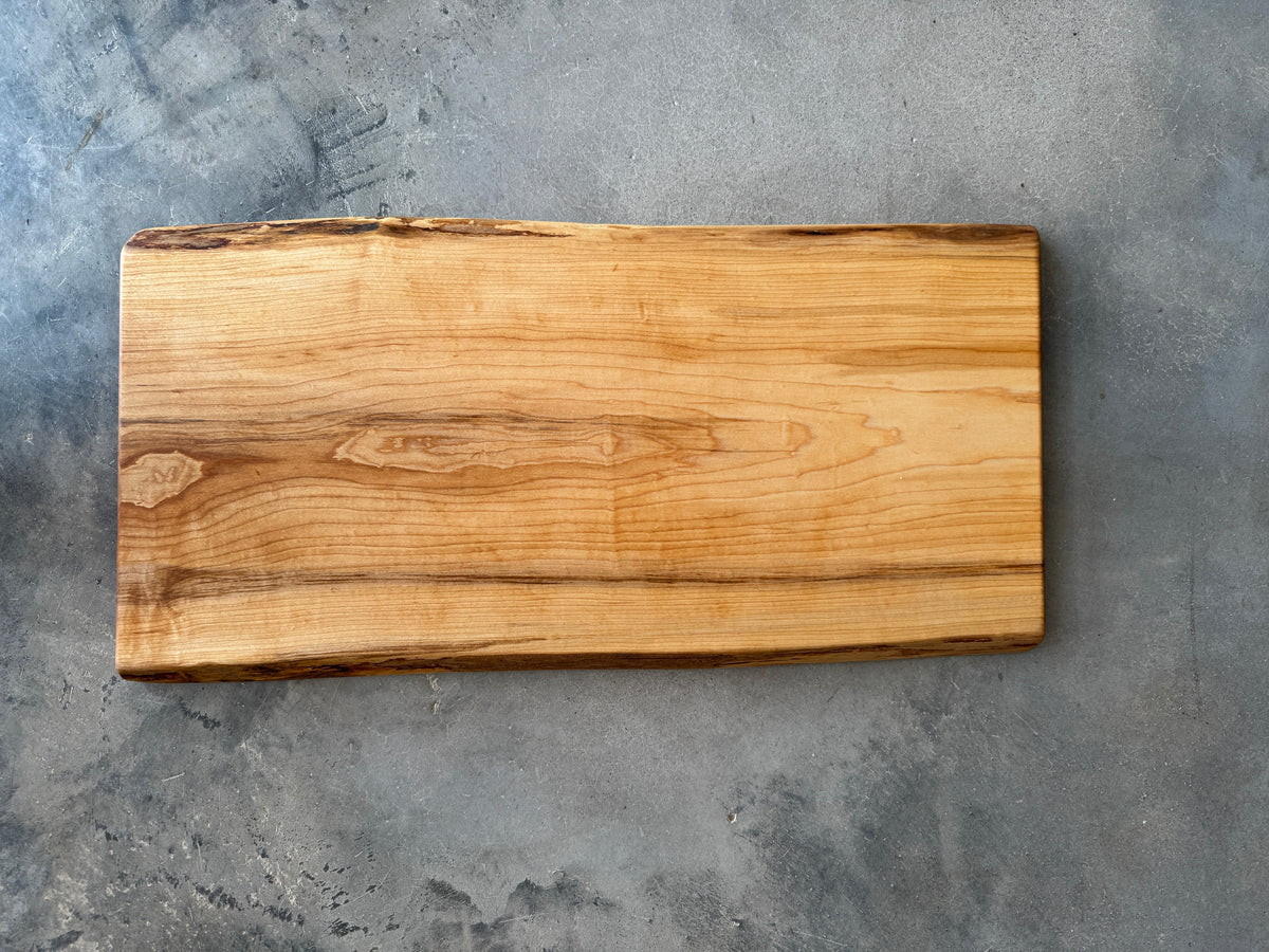 A large live edge rectangle maple charcuterie board, smooth and natural, beautiful wood grain.