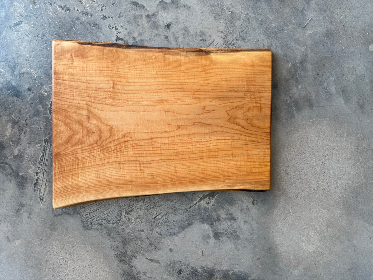 A live edge rectangle maple charcuterie board smooth and natural, beautiful wood grain.