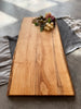 A live edge rectangle maple charcuterie board smooth and natural, beautiful wood grain in focus