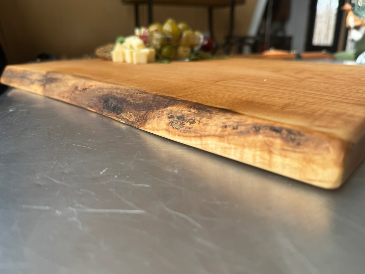 A close up image of the natural live edge on a maple charcuterie board.