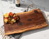 Large personalized charcuterie board with live edges in walnut wood. Engraved with The Johnsons Est. 2024. This serving board has beautiful grain and colouration. Unique for wedding, anniversary and housewarming gifts.
