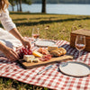 Picnic setup with cheese, bread, and wine on a live edge walnut serving board for a couples date