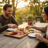 couple on a date enjoying a meal together at an outdoor table with a charcuterie board.