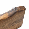 Wooden cutting board with custom handwritten engraved text on a white background, live edge is a highlighted feature