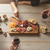 People enjoying Cherry live edge charcuterie board with meat, cheese, and wine spread