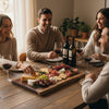 Group of people celebrating a meal with wine and live edge walnut charcuterie board 
