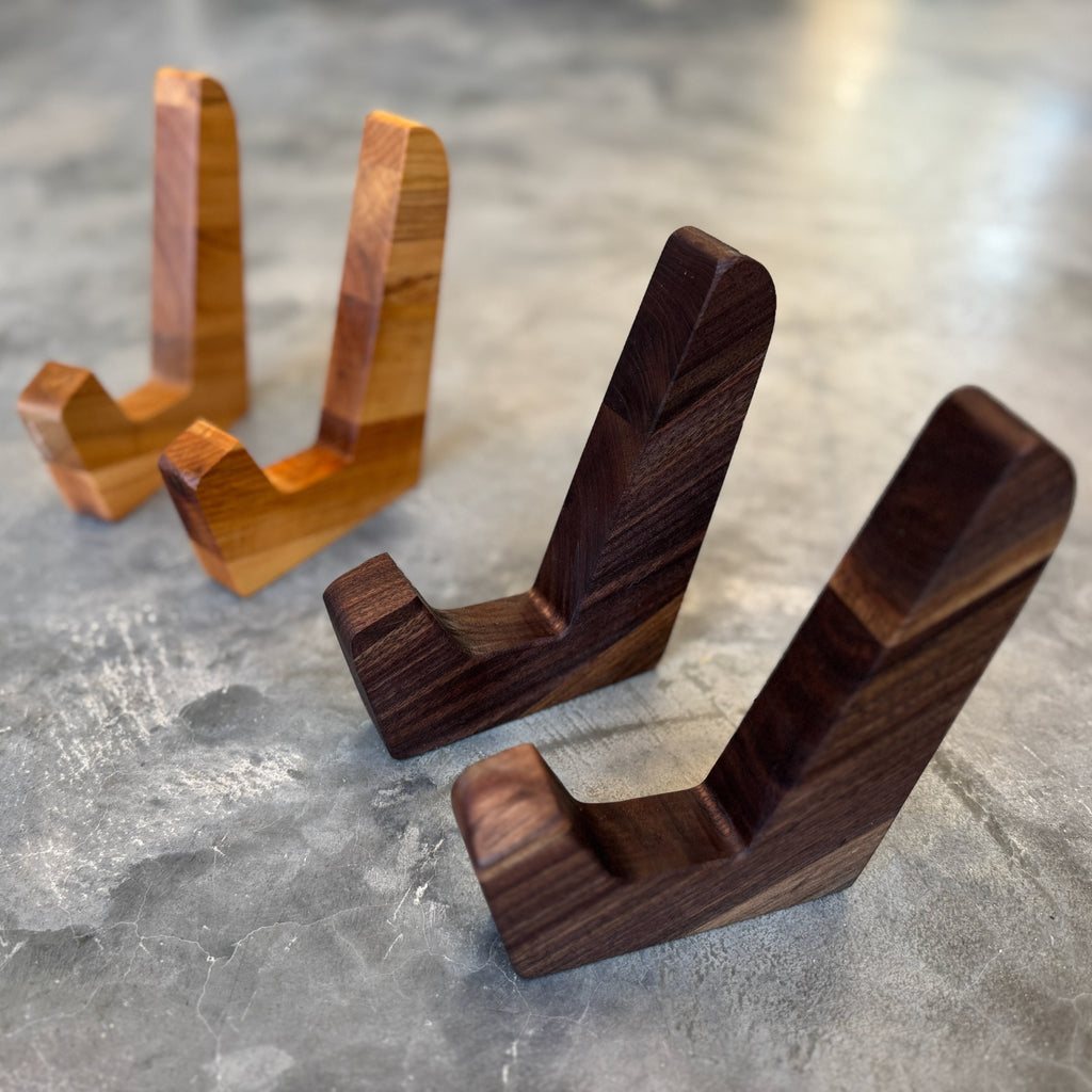 Two standing sets of cutting board stands. One set is maple and one set is walnut