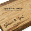 Close-up of personalized maple charcuterie board showing precision engraving of names and date with smooth hand-finished wood grain. 